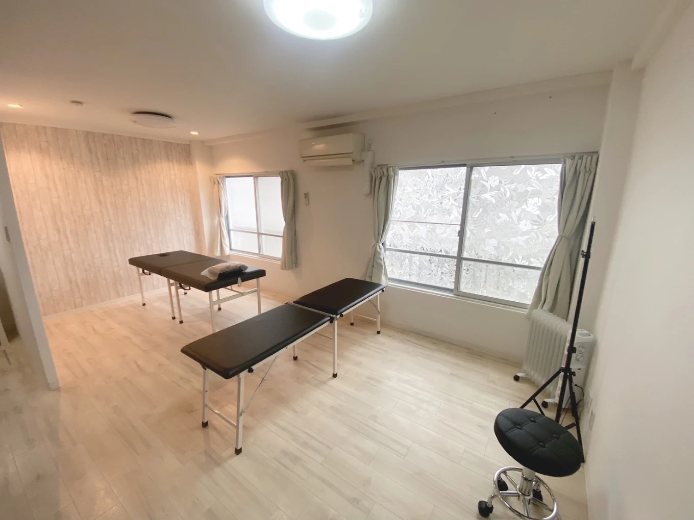 Treatment room at the Yokosuka clinic — two treatment tables in a bright room with curtained windows, on the second floor of Mizuno Building.